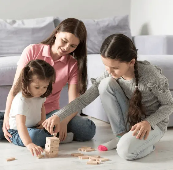 SER AUPAIR childcare Una joven compartiendo actividad de juegos con niños, reflejando lo que implica realmente ser au pair: un intercambio cultural basado en el cuidado y la convivencia familiar.
